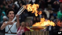 L'actrice Katerina Lehou porte la flamme olympique lors d'une cérémonie à Athènes, le 31 octobre 2017.