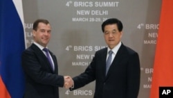 Russia's President Dmitry Medvedev (L) shakes hands with his Chinese counterpart Hu Jintao during their bilateral meeting in New Delhi, March 28, 2012. 