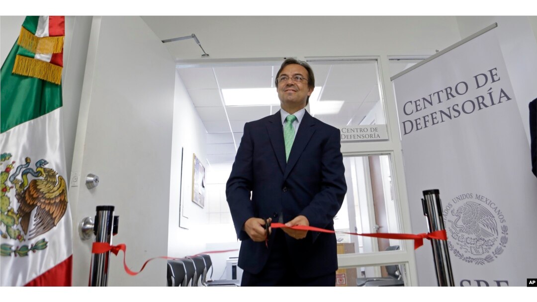 Mexican Consul General Jose Antonio Zabalgoitia cuts a ribbon at the opening of a legal defense center in Miami.
