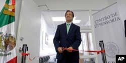 Mexican Consul General Jose Antonio Zabalgoitia cuts a ribbon at the opening of a legal defense center in Miami.