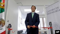 Mexican Consul General Jose Antonio Zabalgoitia cuts a ribbon at the opening of a legal defense center in Miami.
