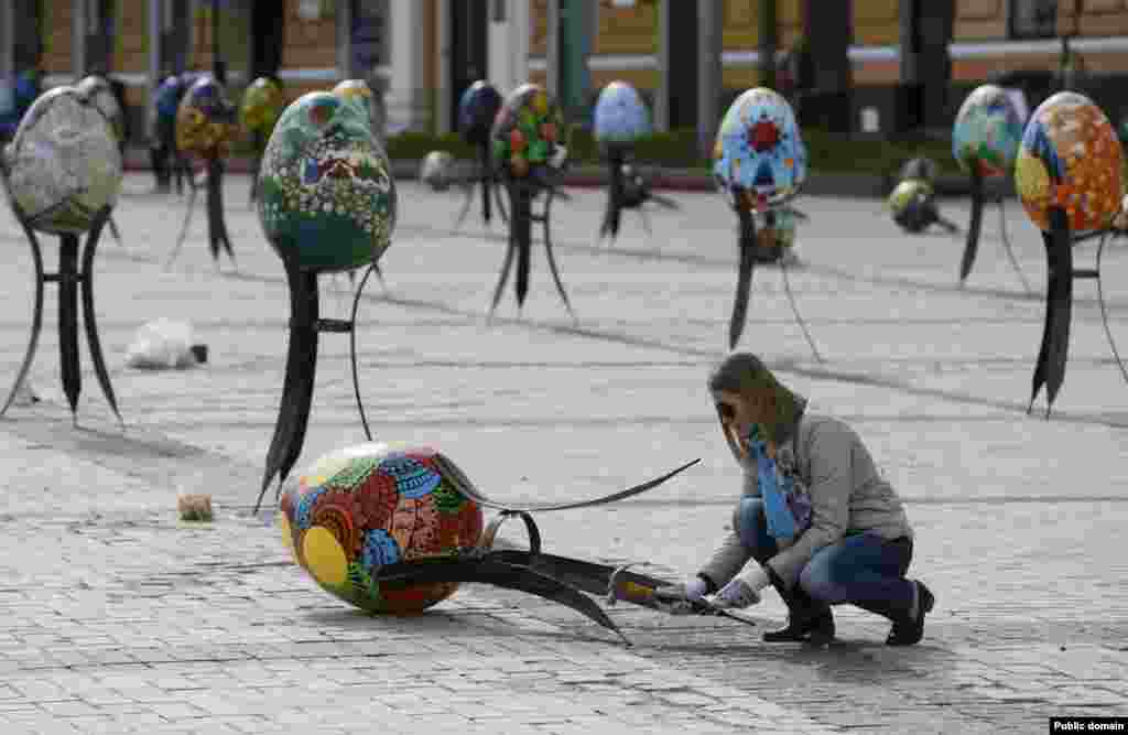 A volunteer adjusts a traditional Ukrainian Easter egg &quot;Pysanka,&quot; as part of the upcoming Easter celebration, in central Kyiv, Ukraine.