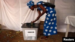 FILE - A woman voter casts her ballot during Rwanda's presidential election, in Kigali, Aug. 9, 2010. 