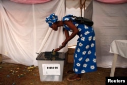 FILE - A woman voter casts her ballot during Rwanda's presidential election, in Kigali, Aug. 9, 2010.