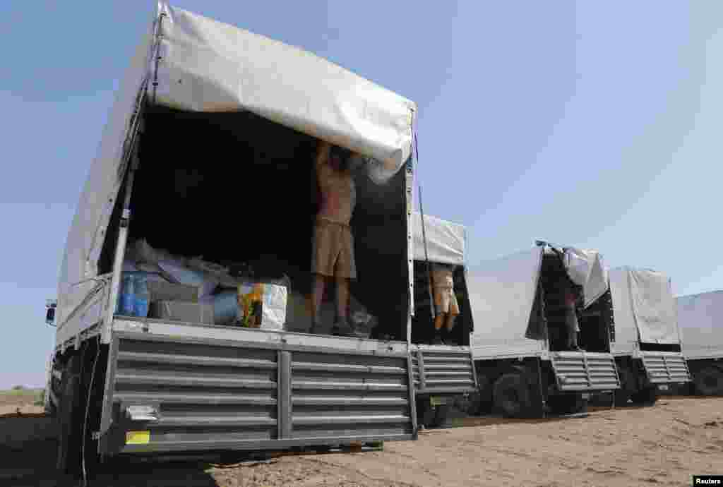 Drivers of a Russian convoy of trucks carrying humanitarian aid for Ukraine open the trucks for inspection at a camp near Kamensk-Shakhtinsky, Rostov Region, Aug. 15, 2014.