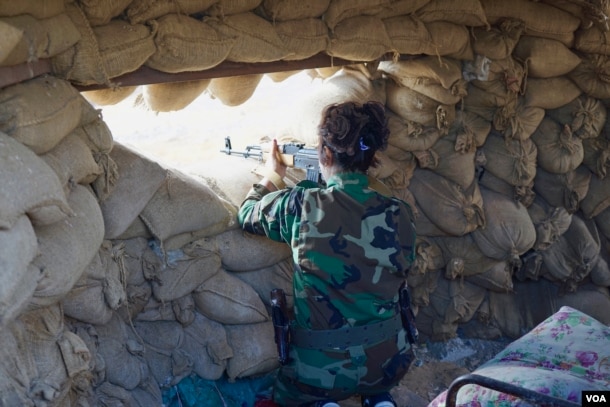 Masuma, 28, an Iranian Kurd volunteer, stands guard observing IS fighters nearby, Nov. 2, 2016. Her brother is fighting alongside her. Before enlisting to fight, they were mule smugglers in Iran. (J. Dettmer/VOA)