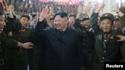 Pemimpin Korea Utara, Kim Jong-un (tengah), merayakan suksesnya peluncuran rudal balistik antar benua "Hwasong-14" tanggal 4 Juli 2017. 