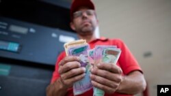 En esta foto de octubre de 2019, Orlando Godoy cuenta sus billetes de bolívares, la moneda local, en San Antonio de los Altos, en las afueras de Caracas, Venezuela.