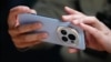 (FILE) A man uses a smartphone during a presentation on the eve of the Mobile World Congress in Barcelona on February 25, 2024.