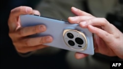 (FILE) A man uses a smartphone during a presentation on the eve of the Mobile World Congress in Barcelona on February 25, 2024.