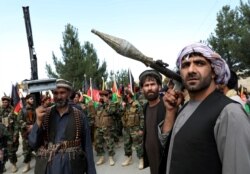 Armed men attend a gathering to announce their support for Afghan security forces and that they are ready to fight against the Taliban, on the outskirts of Kabul, June 23, 2021.