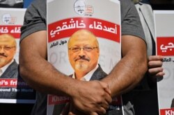 Friends of slain Saudi journalist Jamal Khashoggi hold posters bearing his picture as they attend an event marking the second-year anniversary of his assassination in front of Saudi Arabia Istanbul Consulate, on Oct. 2, 2020.