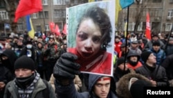 抗議者手舉車娜沃爾的照片。記者車娜沃爾發表有關高層政府官員資產的報道後被毒打。2013年12月26日
