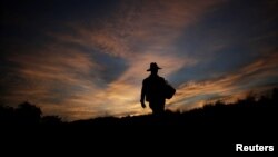 A migrant, traveling with a caravan of thousands from Central America en route to the United States, walks along the highway to Juchitan from Santiago Niltepec, Mexico, Oct. 30, 2018.