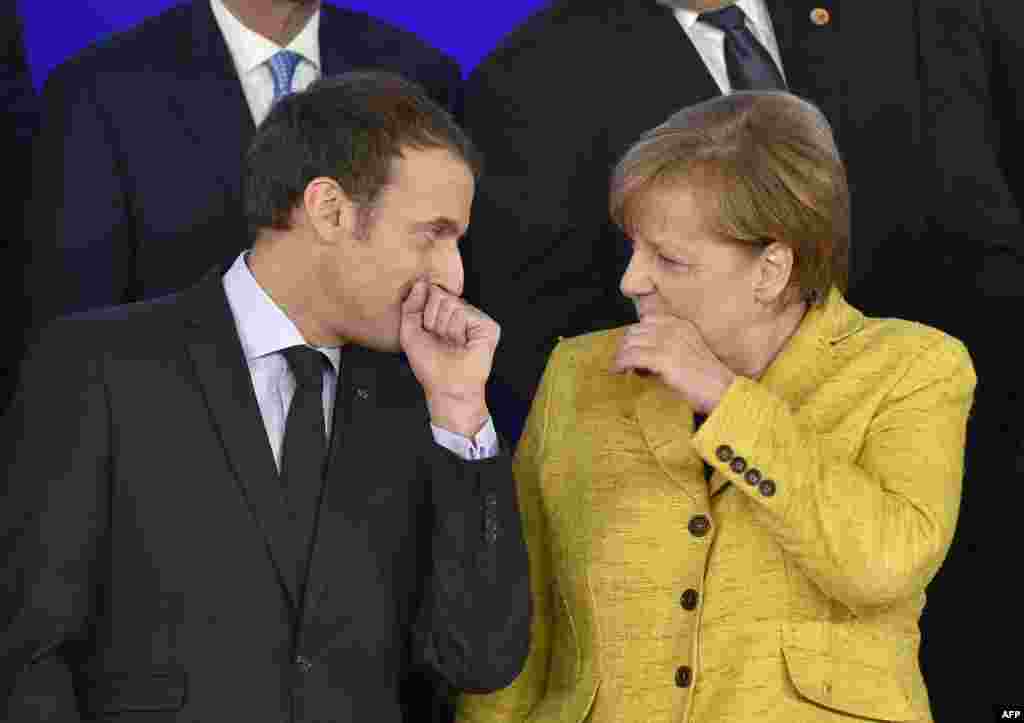 French President Emmanuel Macron talks with German Chancellor Angela Merkel during the family photo after the Reinforcing European Defence meeting on first day of a European union summit in Brussels at the EU headquarters.