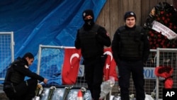 Yon ajan polis kap gade foto viktim atak ak zam ki te fèt nan yon bwat de nui nan Istanboul, Tirki premye janvye 2017. Foto: 2 janvye 2017.