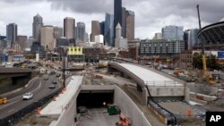 A portion of a new offramp, center right, for Highway 99, stands completed and adjacent to the entrance for northbound traffic into the tunnel being constructed in Seattle. The offramp has a new type of column that flexes when the ground shakes in an earthquake, then snaps back to its original position.