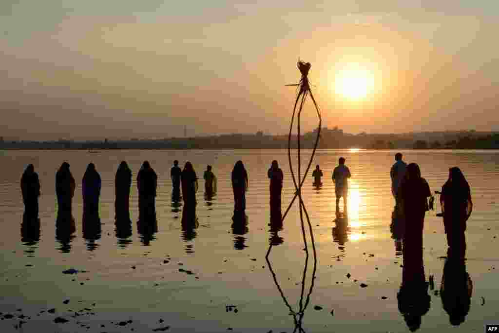 Indianos hindus devotam oferendas ao sol durante o festival de Chhath no lago&nbsp;Hussain Sagar Lake, em Hyderabad .