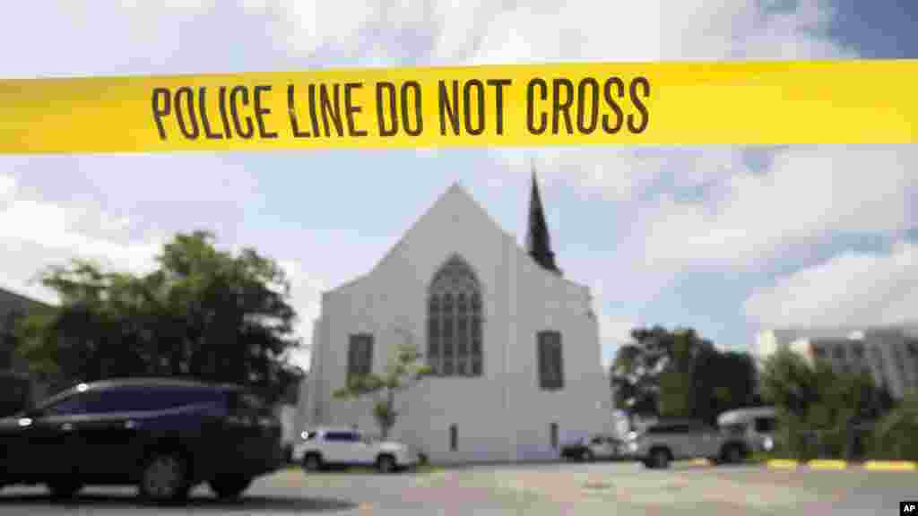 Police tape surrounds the parking lot behind the Emanuel AME Church as FBI forensic experts work the crime scene, June 19, 2015.