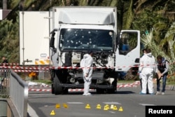 FILE - Investigators continue to work at the scene near the heavy truck that ran into a crowd at high speed killing scores who were celebrating the Bastille Day, July 14 national holiday on the Promenade des Anglais in Nice, France, July 15, 2016.
