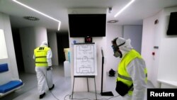 Trabajadores italianos trabajan desinfectando un estadio en Napoles, el 4 de marzo de 2020.
