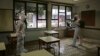 Petugas menyemprotkan cairan disinfektan di sebuah ruangan kelas di Lisbon,Portugal, di tengah pandemi Covid-19, 29 Apri 2020. (Foto: dok). Portugal bersiap-siap menutup semua sekolah mulai dari TK hingga universitas mulai hari Jumat untuk menangani lonjakan tajam kasus Covid-19.