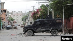 FILE - An armored police van sits in the area where gangs waged intense gun battles, shuttering main avenues and a municipal market in the downtown area of the capital, in Port-au-Prince, Haiti, July 27, 2022.