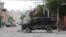 FILE - An armored police van sits in the area where gangs waged intense gun battles, shuttering main avenues and a municipal market in the downtown area of the capital, in Port-au-Prince, Haiti, July 27, 2022.