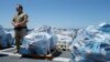 Direktur operasi udara untuk Bea Cukai dan Perlindungan Perbatasan AS Jeremy Battenfield berdiri di samping 13 ton kokain yang disita di lepas pantai Meksiko dan Amerika Selatan Tengah di sebuah pelabuhan di San Diego, California, AS, 26 Juli 2019. (Foto: