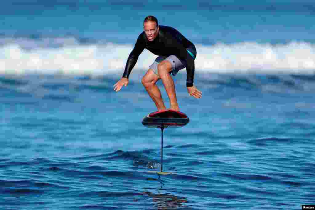 Surfer Chuck Patterson rides his foil board on a morning swell of the coast of Del Mar, California.