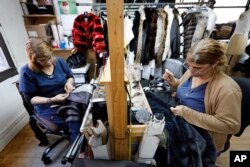 In this April 10, 2019, photo, seamstresses Sonia Genao, left, and Juana Rodrize work on coats at Pologeorgis Furs in New York.