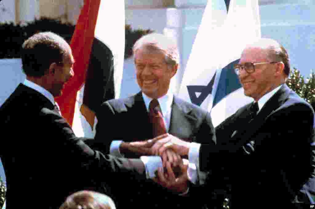 In this March 26, 1979 file photo, from left, Egyptian President Anwar, U.S. President Jimmy Carter and Israeli Prime Minister Menachem Begin clasp hands after signing the Camp David Accords. The historic agreement negotiated by Carter ended the hostilities between Israel and Egypt. (AP Photo/Bob Daugherty, File) 