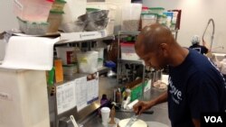 Warren Brown frosts a cake at his CakeLove bakery, Arlington, VA, September 22, 2014 - J.Taboh, VOA