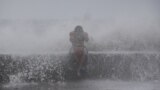 A Filipino reacts as he is hit by waves along a promenade in Manila, Philippines, Sept. 14, 2014. 
