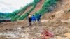 Penduduk desa mengarungi lumpur setelah tanah longsor membanjiri sebuah desa di distrik Phuoc Loc, provinsi Quang Nam, Vietnam Kamis, 29 Oktober 2020. (Foto: AP)