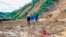 Villagers wade through mud after a landslide swamps a village in Phuoc Loc district, Quang Nam province, Vietnam Thursday, Oct. 29, 2020. Three separated landslides triggered by Typhoon Molave killed more than a dozen villagers in the province as…