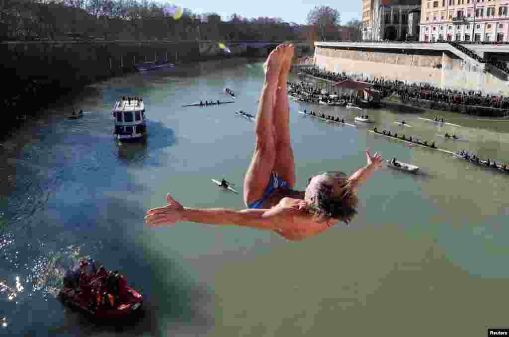 Marco Fois, dives into the Tiber River from the Cavour bridge, as part of traditional New Year celebrations in Rome, Italy.