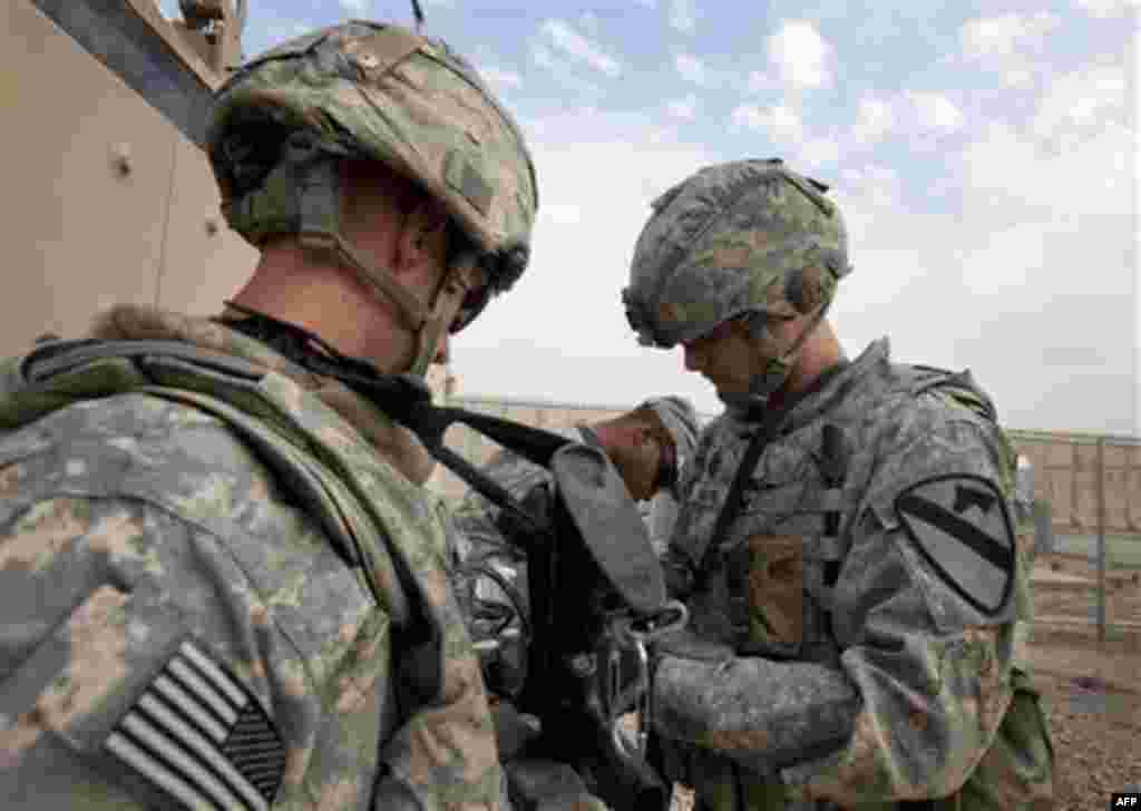 CORRECTS DATE TO FRIDAY - In this Friday, Dec. 16, 2011 photo, Sergeant Daniel Martin, right, of the 3rd Brigade Combat Team, 1st Cavalry Division checks the equipment of Specialist Matthew Syperda outside a Mine Resistant Ambush Protected (MRAP) vehicle 