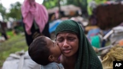A Rohingya Muslim child kisses his mother's cheek as they rest after having crossed from Myanmar to the Bangladesh side of the border near Cox's Bazar's Teknaf area, Sept. 2, 2017. Tens of thousands have crossed into Bangladesh in the last 24 hours as the