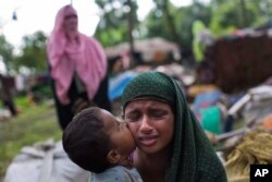 Seorang anak Muslim Rohingya mencium pipi ibunya saat mereka beristirahat setelah berhasil menyeberang ke Bangladesh dari Myanmar di perbatasan dekat kawasan Teknaf, Cox's Bazar, 2 September 2017. Puluhan ribu warga Rohingya telah menyeberang ke Bangladesh dalam 24 jam terakhir dengan kapal atau berjalan kaki untuk menghindari kekerasan di Myanmar barat, menurut UNHCR Sabtu (2/9).