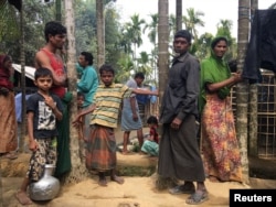 Rohingya Muslims gather outside their makeshift homes on land belonging to Bangladeshi farmer Jorina Katun near Kutapalong refugee camp in the Cox's Bazar district of Bangladesh, Feb. 9, 2018.