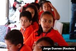 Migrant children take English lessons at a bus converted in a classroom as part of Schools On Wheels program by California's 'Yes We Can' organization, in Tijuana, Mexico August 2, 2019.