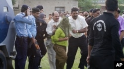 Pakistani police officials escort a young Christian girl accused of blasphemy for allegedly burning pages of a Quran, toward a helicopter following her release from central prison on the outskirts of Rawalpindi, September 8, 2012.