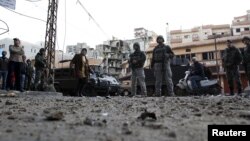 Residents and Lebanese army soldiers inspect damage following days of clashes between Sunni Muslims and Alawites in the port-city of Tripoli, northern Lebanon, December 10, 2012. 