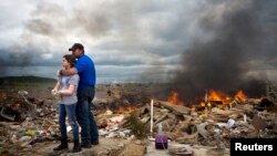 Michael Stanek memeluk putrinya Kennedy saat beristirahat dalam membantu kawan-kawan mereka membersihkan puing-puing akibat banjir besar di Vilonia, Arkansas, April 2014. (Reuters/Carlo Allegri)