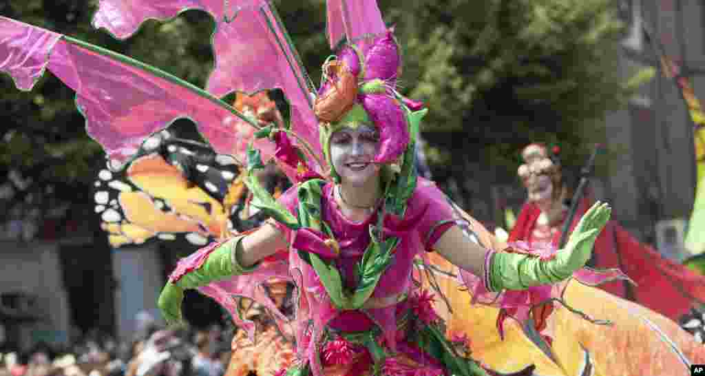 ​یک شرکت کننده در کارناوال &laquo;فرهنگ&zwnj;ها&raquo; در برلین آلمان در روز یکشنبه در حال رقص. در این کارناوال، ملیت&zwnj;ها و اقوام مختلف با نمادهای فرهنگی خود در قالب این کارناوال رژه می روند.