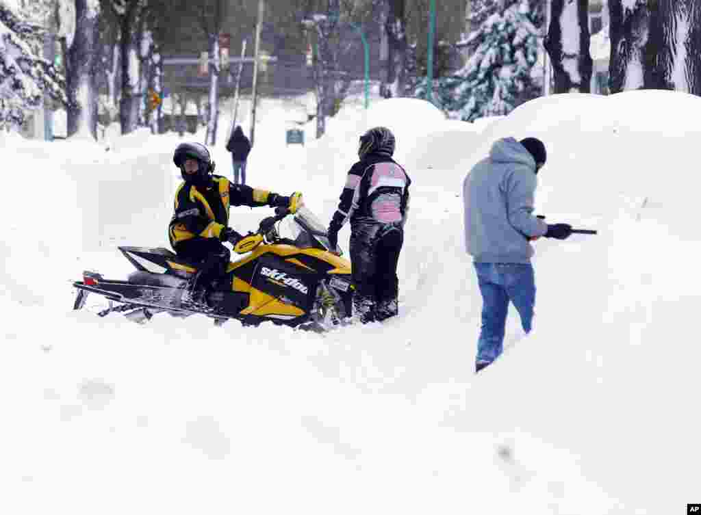Une motoneige est obligée de faire demi-tour dans une rue de neige bouchée dans la zone sud de Buffalo, jeudi 20 novembre 2014, à Buffalo, NY.