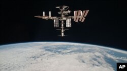This May 23, 2011 photo released by NASA shows the International Space Station above the Earth, taken by Expedition 27 crew member Paolo Nespoli from the Soyuz TMA-20 following its undocking.