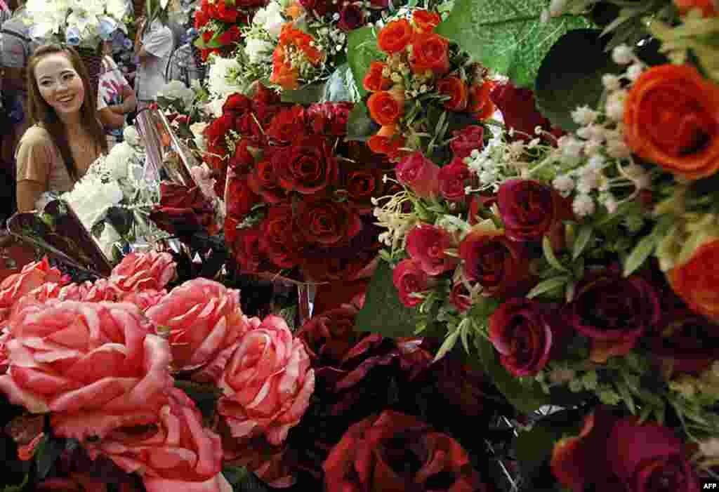 A woman looks at roses for Valentine's Day at a flower shop in Bangkok February 14, 2012. (REUTERS)
