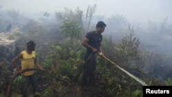 Petugas memadamkan kebakaran di hutan di Bengkalis, Riau. (Foto: Dok)